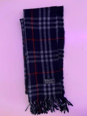 Burberry skarf blå - Detta är en jättefin burberry skarf i en blå färg med ett rutat mönster på. Köpt på Von Greven Closet.