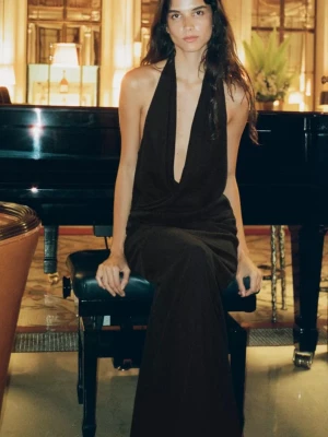 Svart långklänning med öppen rygg - Elegant svart långklänning med djup v-ringning och halterneck. Klänningen har en öppen rygg! 