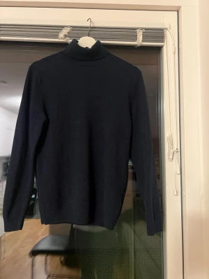 Mörkblå polotröja Massimo Dutti - Säljer en mörkblå polotröja från Massimo Dutti i mjuk kashmir. Klassisk modell med lång ärm och hög polokrage. Perfekt till lager på lager och riktigt skön mot huden. Enkel och stilren design utan mönster eller detaljer.