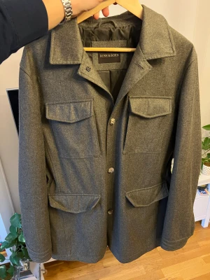 Rose & Born field jacka Kashmir/ ull  - Säljer en otroligt vacker och välgjord jacka från Rose & Born, ett av Sveriges mest exklusiva herrmodehus. Jackan är i nästan perfekt skick och har endast använts ett par enstaka gånger – den ser i princip helt ny ut. Nypris omkring 15 000 kr, och kvaliteten motsvarar varje krona. Det här är en jacka som verkligen känns genomtänkt. Materialet är mjukt och följsamt med en lyxig textur, samtidigt som det är robust nog att hålla i många år framöver. 