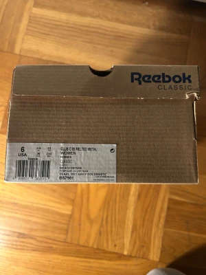 Reebok Club C 85 Melted Metal sneakers - Snygga Reebok Club C 85 Melted Metal sneakers i metallic guld med vit platt sula. Skorna har snörning och är tillverkade i skinn med klassisk Reebok-logga på sidan. Perfekt för dig som vill sticka ut med en glansig och modern look. Strl i lager: 35.5, 36.6, 36, 37