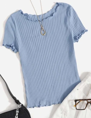 Ljusblå ribbad topp med volangkant - Säljer en ljusblå ribbad topp med korta ärmar och volangkant vid halsringning, ärmslut och nederkant. Toppen har en slim passform och är tillverkad i mjuk bomull. Perfekt för dig som gillar enkel men snygg stil.