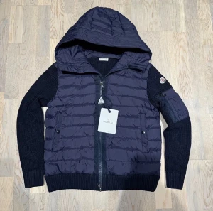 Mörkblå Moncler pufferjacka med huva/Passar storlek L - Snygg mörkblå pufferjacka från Moncler med stickade ärmar och huva. Skick-9/10✅ pris ej hugget i sten minsta fundering hör av dig 😁