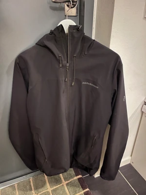Peak Performance vindjacka-Svart, S - Svart Peak Performance vindjacka i stl S. Nypris 2200 kr. Fint skick förutom trasig dragkedja på höger ficka. Tveka inte att höra av dig om du vill ha fler bilder eller har frågor! 