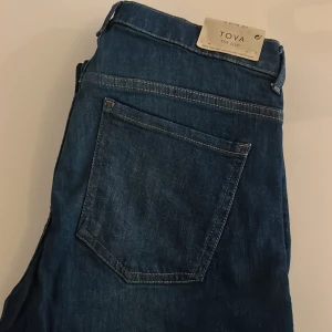 Blå slim jeans Tova från Lindex - Mörkblå jeans från Lindex, modell Tova The Slim. Klassisk femficksdesign med smal passform och normalhög midja. Jeansen är tillverkade i stretchig bomullsmix för extra komfort och har snygga kontrastsömmar.