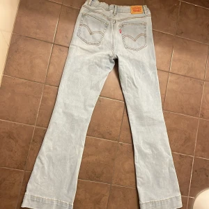 Levi's 726 Flare ljusa jeans - Snygga ljusblå Levi's 726 Flare jeans med klassisk femficksdesign. Modellen har utsvängda ben och är mid waist, strl s/m är stretchig i materialet.