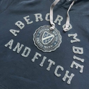 Mörkblå hoodie från Abercrombie & Fitch - Tvärrrfet mörkblå hoodie från Abercrombie i stl L. Modellen på bilen är 186, väger 80 kg. Dm:a för fler bilder, mått osv Pris kan diskuteras vid snabb affär! Ha det gött :)