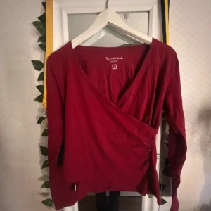 Röd omlottopp från Bondelid - En röd tröja med en design som ser ut som en knyttröja men utan att knyta, perfekt ju!! 💕 I storlek S och har aldrig använt den! Perfekt vinröd färg inför hösten! Kommer inte skicka bild hur den ser ut på då jag ser konstig ut i den. Tar ej emot returer!!