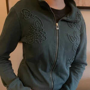 Mexx hoodie med brodyr  - Mörkgrön Hoodie med vackra brodyrer från märket Mexx. Storlek M, liten i storleken. I bra använt skick. 