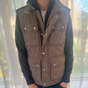 Quilted väst - Beige väst ifrån zara med mocka detaljer på ryggen. Storleken är M📏 Modellen är 177cm och väger 65KG. Västen är unik och säljs inte längre🌟Skriv för mer info🌟