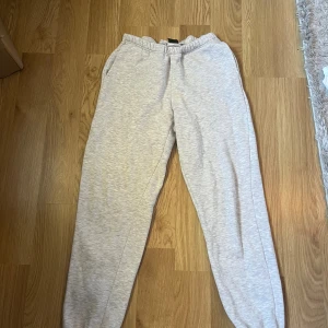 Ljusgrå mjukisbyxor från Gina Tricot XXS - Ljusgrå mjukisbyxor från Gina Tricot i storlek XXS. Byxorna har resår i midjan och vid bensluten samt sidofickor. Perfekta för en chill och avslappnad stil. Tillverkade i mjukt bomullsmaterial för extra komfort.