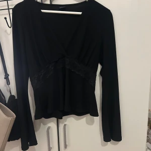 Gina blus -  Jag säljer en svart blus med spetskant runt midjan. Tröjan är använd två gånger så i princip nyskick🫶