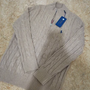 Beige kabelstickad quarter zip Polo Ralph Lauren - Helt ny Kabelstickad beige tröja från Polo Ralph Lauren med halv dragkedja, M, 1t1, skickas samma dag.