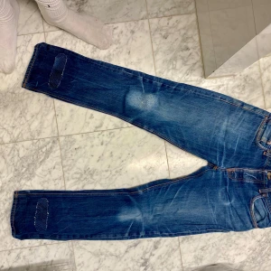 Blå jeans från Nudie med lagningar - Byte 