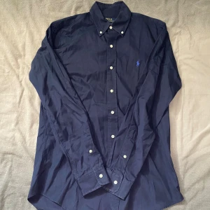 Mörkblå skjorta från Polo Ralph Lauren - Mörkblå skjorta från Ralph Lauren i storlek S. Fint skick till ett bra pris. Nypris: 1995kr. Mitt pris: 299kr                  Vid frågor eller funderingar, tveka inte att höra av dig.