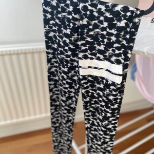 Svarta/ vita träningstights  - Snygga leggings från Lager 157 i svartvitt abstrakt mönster med två vita ränder på ena benet. Stretchigt material som sitter tight och bekvämt. De är i storlek 160, men skulle säga att dem är en S/XS