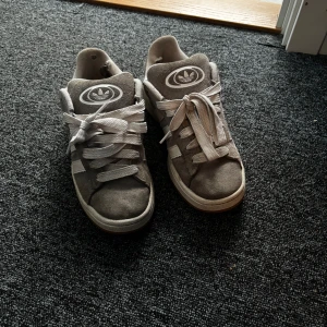 Grå Adidas Campus - Grås adidas campus som är i fint skick på utsidan men lite slitna inuti se bild 4 och 5