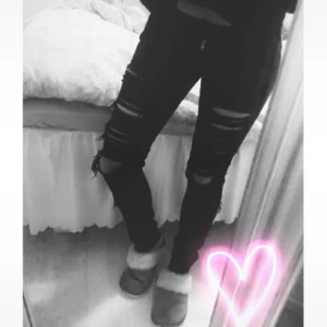 Svarta ripped skinny jeans! - Säljer ett par svarta jeans med snygga slitningar och hål över knäna och låren. Modellen är skinny med låg midja och tajt passform. Jeansen har klassisk dragkedja och knapp framtill. Perfekt för dig som gillar en edgy och trendig stil.