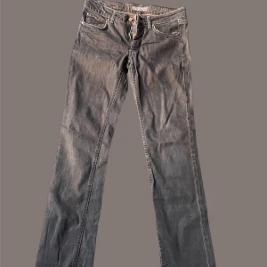 Svarta/bruna jeans från Acne Jeans - Säljer ett par svarta/bruna jeans från Acne Jeans med klassisk femficksdesign och raka ben. Jeansen har normal midja och är tillverkade i bomull med snygga kontrastsömmar. Perfekta för dig som gillar stilrena och tidlösa byxor.