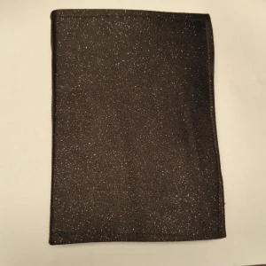 Tom anteckningsbok med glittrigt svart omslag - En stilren handgjord anteckningsbok med svart, glittrande omslag och blanka sidor av printerpapper. Perfekt för dig som vill skriva, rita eller skapa din egen berättelse. Passar både till skolan, jobbet eller som dagbok. Låt kreativiteten flöda i denna unika bok! A6 storlek.