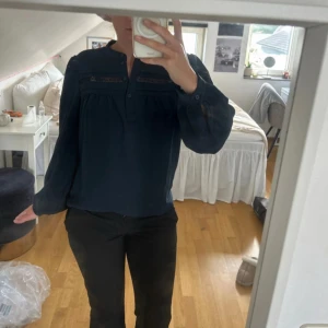 Söt  blus med detaljer - Säljer en marinblå blus med långa ärmar och fina detaljer upptill. Blusen har knappar framtill och en lös passform som ger en avslappnad men ändå stilren look. Perfekt till både jeans och kostymbyxor. Den är köpt på only och säljs inte längre 
