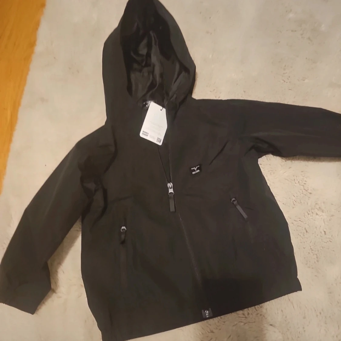 Svart vindjacka med huva