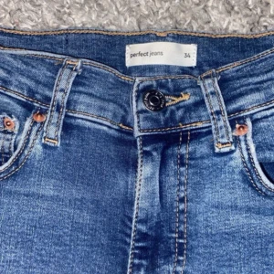 Blå bootcut jeans från Perfect Jeans - Snygga blå jeans från Perfect Jeans i storlek 34. Modellen har klassisk femficksdesign, medelhög midja och bootcut-ben. Jeansen är tillverkade i stretchigt denim för en bekväm passform och har snygga kontrastsömmar.