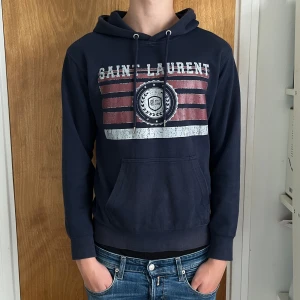 Saint Laurent Hoodie - Mörkblå Saint Laurent hoodie i storlek S. Den är i mycket bra skick och endast använd fåtal gånger. Pris kan diskuteras. Hör av er vid frågor! Självklart äkta!