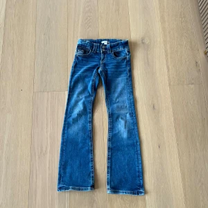 Blå Low waist bootcut jeans  - Snygga blå jeans low waist bootcut. Med en knapp ficka på framsidan.