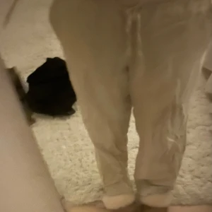 Beiga linnebyxor med snörning - Säljer ett par beiga linnebyxor från Gina Tricot med avslappnad passform och snörning i midjan. Byxorna har elastisk midja och är perfekta för en chill och stilren look. Lätta och luftiga, perfekta för varmare dagar.