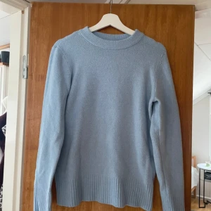 Ljusblå stickad  - Mysig ljusblå stickad tröja med rund halsringning och ribbade muddar vid ärmslut och nederkant.