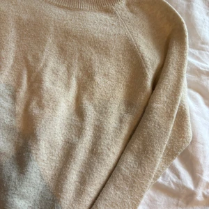Beige stickad tröja från Vero Moda - Mysig beige stickad tröja från Vero Moda med rund halsringning och ribbade muddar. Perfekt för lager-på-lager och chill dagar. Enkel och stilren design som funkar till allt.