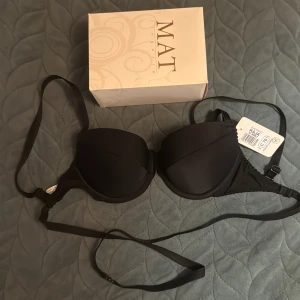 Svart bh från MAT Kaja - Säljer en svart bh från MAT Kaja i storlek C70 men jag tror att den är 70 B.Bh har avtagbara och justerbara axelband, slät design och lätt vadderade kupor. Perfekt för dig som vill ha en enkel och stilren look. Materialet är mjukt och följsamt syntet.