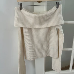 Offshoulder ribbad stickad tröja - Superfin offshoulder tröja i ribbstickat material från H&M. Tröjan är krämvit och aldrig använd. Väldigt mysig och bra till hösten.