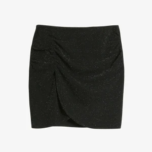 Svart glittrig omlottkjol - Snygg svart kortkjol med glittriga detaljer och omlott-design. Har knappt använt kjolen endast en gång. Kjolen kommer från kaphal. Nypris 250