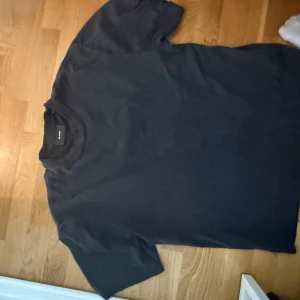 Svart t-shirt Axel Arigato med tryck - Svart t-shirt från Axel Arigato i 100% ekologisk bomull. På ryggen finns ett broderat tryck med Pink Panther och text. Modellen är klassisk med rund hals och korta ärmar, perfekt för dig som gillar streetwear och snygga detaljer.