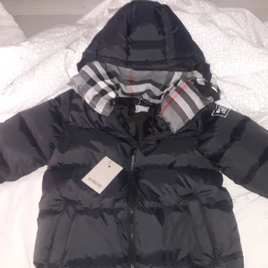 Burberry jacka - Här har vi ek burberry jacka gjord av mig! Den är i stolek S men passar stolek 158-164 164/xs. Den är varm och skön och en ganska så bra vinterjacka jackan själv e helt ny men inte där burberry materialet sitter p har synts men annars är jackan bra.
