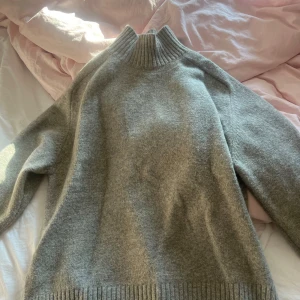 Polotröja  - Grå stickad tröja med polo. Tröjan är använd fåtal gånger och har inga tecken på användning. 