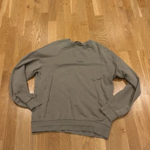 Beige sweatshirt från Jack & Jones - Säljer en stilren beige sweatshirt från Jack & Jones Premium. Tröjan har rund halsringning, ribbade muddar och diskret logga på bröstet. Perfekt för en avslappnad look och enkel att matcha med jeans eller joggers.