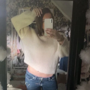 Vit stickad tröja - Supermysig ljusbeige stickad tröja med croppad passform och långa ärmar. Tröjan har en rund halsringning och är perfekt för lager-på-lager. Den är mjuk och har en lite lös siluett som ger en chill vibe.