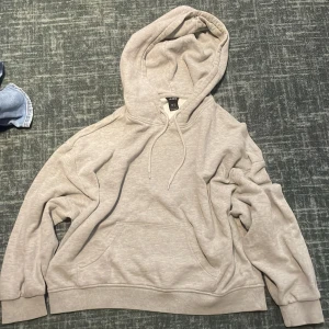 Ljusgrå hoodie från Lindex i M - Mysig ljusgrå hoodie från Lindex i storlek M. Tröjan har huva med snörning, stor känguruficka framtill och ribbade muddar. Perfekt för chill dagar eller när du vill ha en enkel och stilren look. Inga fläckar eller skador, använd max 3 gånger<3