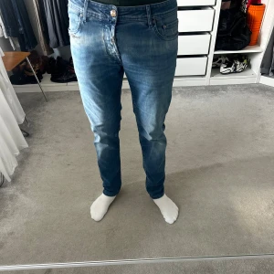 Blå jeans från Jacob Cohen - Snygga blå jeans från Jacob Cohen med klassisk femficksdesign och knappgylf. Jeansen har en rak passform och coola detaljer som broderad text på insidan. Tillverkade i mjukt denimtyg som sitter skönt hela dagen.