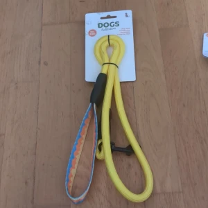 Hundkoppel - Färgglatt och slitstarkt hundkoppel från DOGS Collection, max 25 kg. Nytt i förpackning, med bekvämt handtag och säker karbinhake. Perfekt för dagliga promenader med din hund. Inga synliga defekter eller slitage.