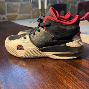 Svarta och röda Jordan sneakers - Säljer ett par svarta och röda Jordan sneakers med coola detaljer som nummer 23 på sidan och Jumpman-logga under sulan. Skorna har snörning, mesh och skinnpaneler samt en robust sula för extra grepp. Perfekta för dig som gillar streetstyle och basketinspirerad look.