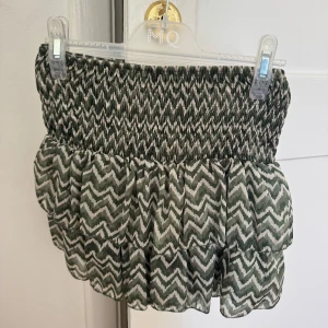 Grönvit kortkjol med volanger - Supersöt kortkjol med grönt och vitt zigzag-mönster. 