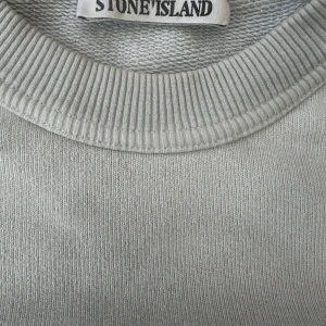 Ljusblå sweatshirt från Stone Island - Ljusblå ”Vintage”? stone island sweatshirt, storlek s. Köpt på nk i stockholm. knappt använd, i mycket bra skick –  som ny. 
