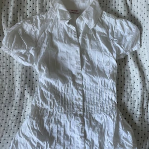 Figursydd blus - Vit blus som är figursydd och med lite puffiga axlar.