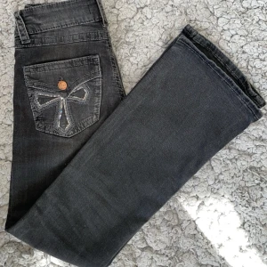 Svarta bootcut jeans med paljettdetalj - Snygga mörk grå/svarta jeans med bootcut passform och coola paljettdetaljer på bakfickorna.💕 Jeansen har inga skador och är knappast använda, behövde sälja för de inte passade mig💕 De är i storlek 152