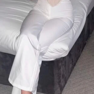 Vita raka kostymbyxor med dragkedja oanvänd  - Snygga vita kostymbyxor  med hög midja och stilren siluett. Byxorna har en diskret dragkedja i sidan för en clean look och är tillverkade i ett mjukt, slätt material som ger en skön känsla. Perfekta för dig som gillar minimalistisk och trendig stil.