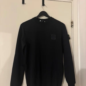 Svart Stone Island sweatshirt - Svart sweatshirt från Stone Island med klassisk patch på vänster ärm. Använd ett fåtal gånger, pris kan såklart diskuteras. Den är storlek S, men känns ganska slim fit. 